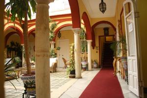 korytarz domu z kolumnami i czerwonym dywanem w obiekcie Hostal Sierpes w Sewilli