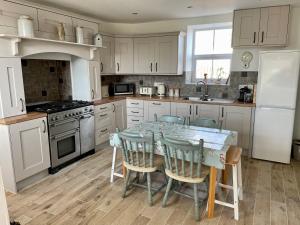 a kitchen with a table with chairs and a sink at Maggie's Croft Cottages 4 Star Tourism NI in Castlewellan