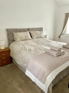 a bedroom with a bed with towels on it at Maggie's Croft Cottages 4 Star Tourism NI in Castlewellan