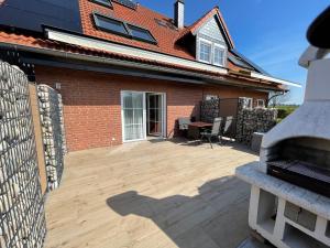 a brick house with a patio with a table and chairs at Fehmarn-OstseeferienFewoAnders11591 in Neue Tiefe Fehmarn
