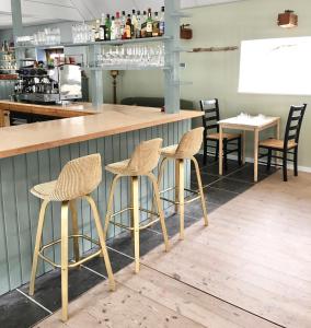 a bar with three stools in front of a counter at Hvidegaard Møn in Stege