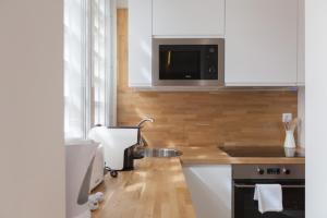 uma cozinha com um lavatório e um micro-ondas em FLH Estefânia Charming Flat em Lisboa