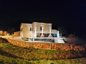 uma casa grande à noite com uma parede de pedra em El Cielo de Muriel mejor Hotel Starlight del mundo Astroturismo y Naturaleza em Muriel Viejo