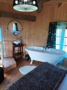 - une salle de bains avec baignoire dans une chambre dotée de murs en bois dans l'établissement La Tour de Ver Gite atypique Possibilité table d'hôtes sur réservation, à Ver