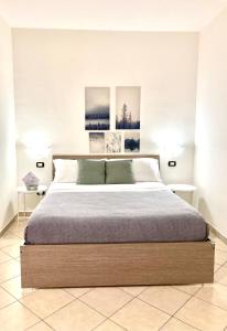 sypialnia z dużym łóżkiem z dwoma obrazami na ścianie w obiekcie POMPEI FELIX w mieście Pompeje