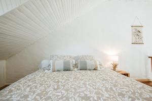 a white bedroom with a bed with pillows on it at Relais des combrailles in Tralaigues