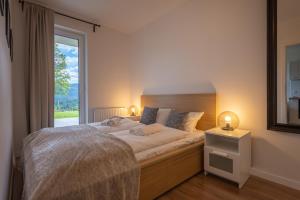 sypialnia z dużym łóżkiem i oknem w obiekcie RentPlanet - Apartamenty Izerska w Szklarskiej Porębie