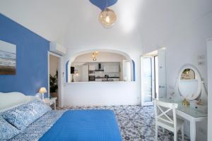 Dormitorio azul y blanco con cama y escritorio en Casa Terry, en Praiano 51 fotos más