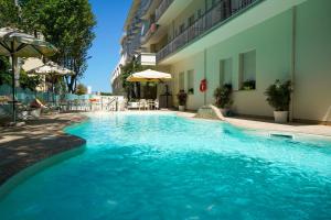 a swimming pool in a hotel with blue water at Hotel Pineta in Bellaria-Igea Marina +75 photos