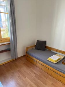 a bedroom with a wooden bed with a window at Studio CV - Calme, clair in Montpellier