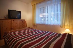 Dormitorio con cama y tocador con TV en Fehmarn-OstseeferienFewoAnders11591, en Neue Tiefe Fehmarn