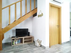 a living room with a television and a staircase at Casa do Alto in Tavira