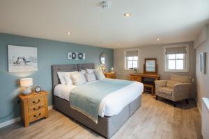 a bedroom with a bed and a desk and a chair at Tŷ Milford Waterfront in Milford Haven