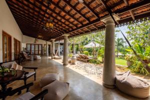 un soggiorno all'aperto con sedie e tavolo di TROPICAL HOUSE - Jungleside Villa a Hikkaduwa