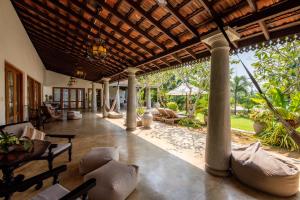 ein Wohnzimmer im Freien mit Stühlen und einem Tisch in der Unterkunft TROPICAL HOUSE - Jungleside Villa in Hikkaduwa