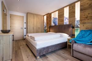 een slaapkamer met een groot bed en houten wanden bij Apartments Pragser Wildsee Winklwiese in Braies