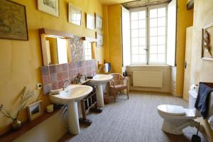 La salle de bains est pourvue de 2 lavabos et de toilettes. dans l'établissement Chambre jaune MANOIR DE LA VOVE Perche, à Corbon