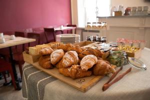 ein Tisch mit einem Tablett mit Brot und Gebäck darauf in der Unterkunft Hotel Broletto in Mantua