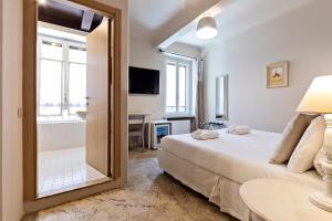 una camera con letto e specchio di Hotel Broletto a Mantova