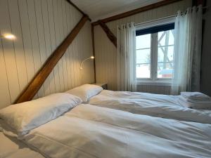 two beds in a room with a window at Sakrisøy Rorbuer in Reine