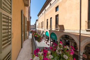 eine Gasse in einer Stadt mit Blumen und Gebäuden in der Unterkunft Hotel Broletto in Mantua