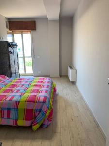 a bedroom with a bed with a colorful comforter at Appartamento Siderno sul mare trilocale in Siderno Marina