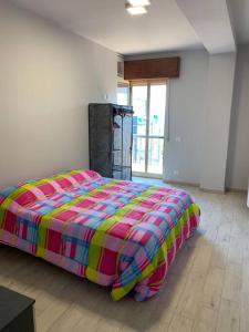 a bedroom with a large bed with a colorful comforter at Appartamento Siderno sul mare trilocale in Siderno Marina