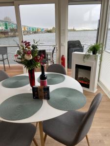 una mesa blanca con sillas y chimenea en Hausboot Claudia Maasbommel en Maasbommel