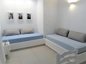 a room with two beds and a chair at Drouga's Studios & Suites Astypalaia Greece in Livadi Astypalaias