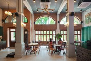 a woman sitting at a table in a restaurant at Ago Hotel Chinatown in Bangkok