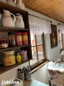 a kitchen with a shelf with dishes and a window at Pension Krasne Udoli in Český Krumlov