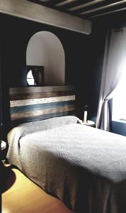 a bedroom with a large bed with a wooden headboard at L' Oustaloun in Maussane-les-Alpilles