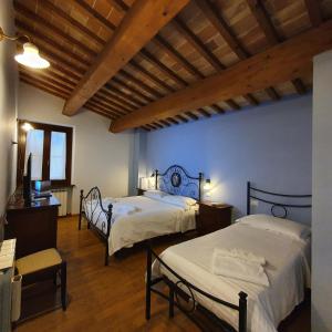 una camera con 2 letti e un soffitto in legno di Pietra Maula Agriturismo a Castelraimondo