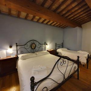 a bedroom with two beds with white sheets at Pietra Maula Agriturismo in Castelraimondo