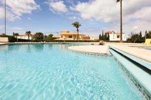 uma piscina com água azul e palmeiras em Palmeira Gale - WIFI - Pool - Lux - BY BEDZY em Albufeira