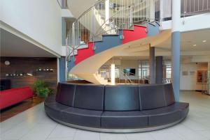 a lobby with a spiral staircase in a building at Ramada by Wyndham Dresden in Dresden