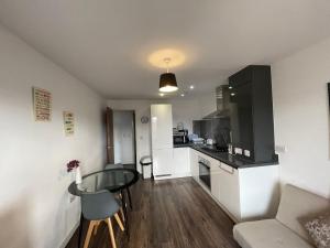 a living room with a table and a kitchen at Modern Apartment near Bullring in Birmingham