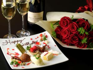 una mesa con un plato de comida y un ramo de rosas en Mercure Yokosuka, en Yokosuka