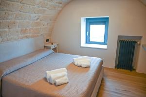 a bedroom with a bed with two towels on it at La casa di Alice in Monopoli