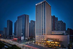 Un palazzo alto in una città di notte di Wyndham Jingzhou a Jingzhou
