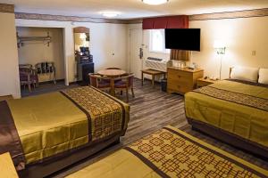 um quarto de hotel com duas camas e uma sala de estar em Rodeway Inn Albuquerque Downtown on Rt 66 em Albuquerque