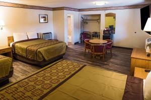 アルバカーキにあるRodeway Inn Albuquerque Downtown on Rt 66のベッド、テーブル、椅子が備わるホテルルームです。