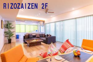 een woonkamer met een bank en een tafel bij リゾザイゼンホテル in Ginowan