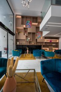 V Hotel في سانت جوليانز: غرفة معيشة مع أرائك زرقاء وكراسي زرقاء