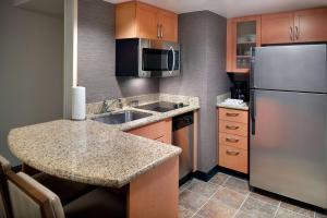 a small kitchen with a sink and a refrigerator at Sonesta ES Suites Atlanta Alpharetta Windward in Alpharetta