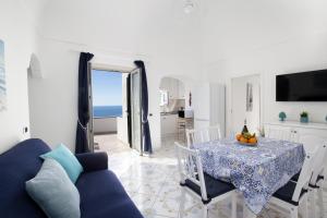 salon ze stołem i niebieską kanapą w obiekcie Estate4home - Casa Darly w mieście Positano