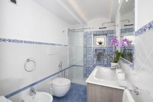 niebiesko-biała łazienka z toaletą i umywalką w obiekcie Estate4home - Casa Darly w mieście Positano +32 zdjęcia
