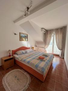 Un dormitorio con una cama grande y una ventana. en Apartment Azalea of Budva, en Budva