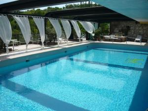 a large swimming pool with blue water at Villa Michelangelo Vicenza – Starhotels Collezione in Arcugnano