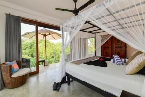 a bedroom with a bed with a mosquito net at TROPICAL HOUSE - Jungleside Villa in Hikkaduwa +122 photos